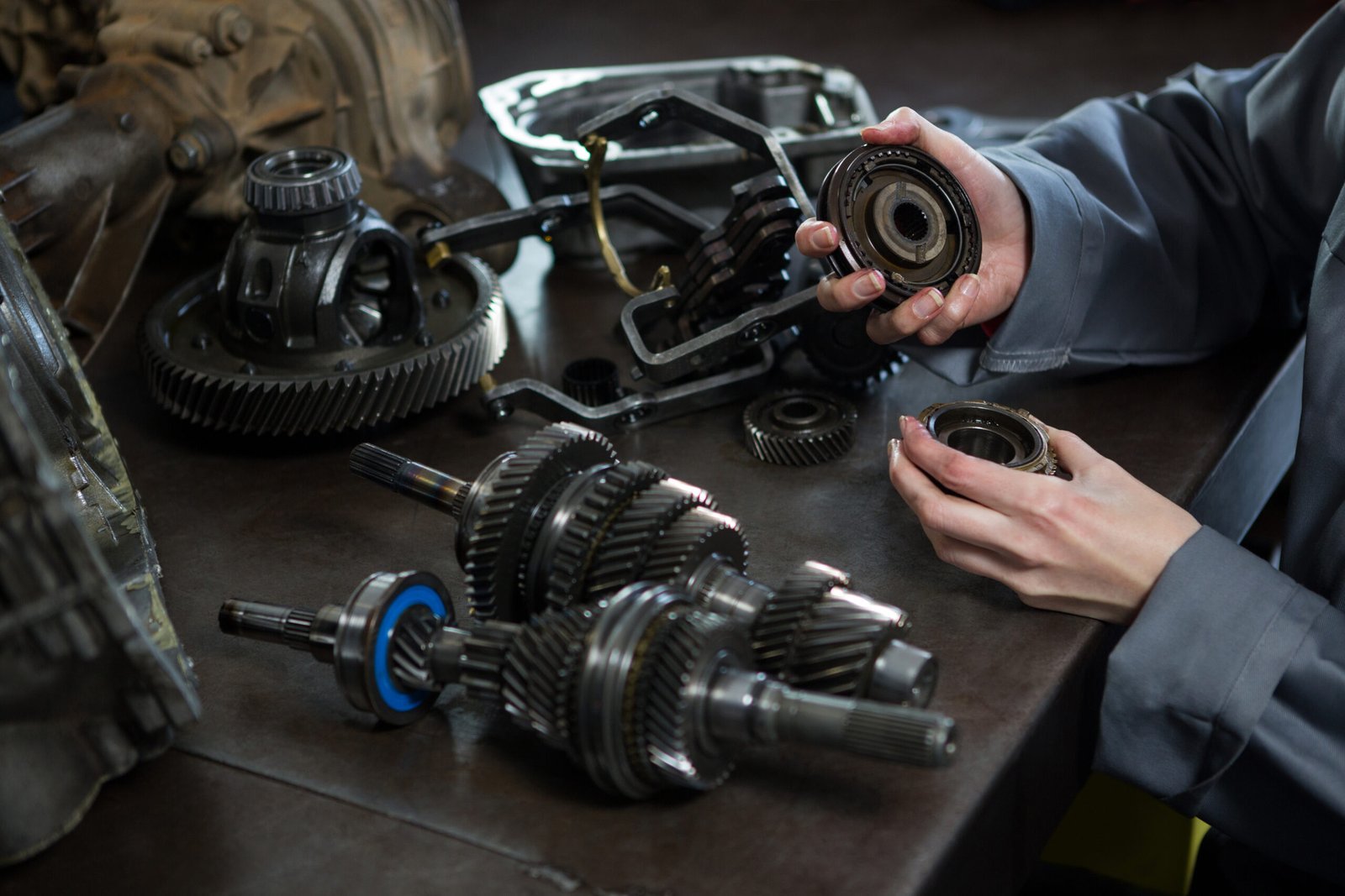 female mechanic holding spare parts of car